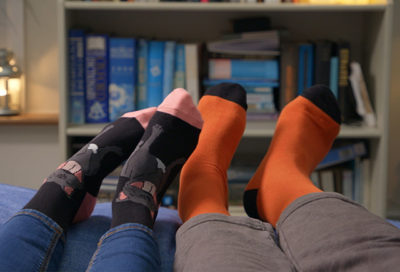 Colourful pair of socks in front of bookcase
