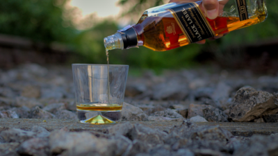 whisky glass on stones on the ground